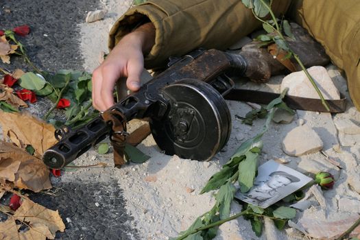 Fallen soldier with drum machine gun.