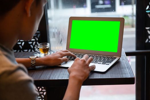 Young entrepreneur SME use notebook showing blank screen with clipping path display  in cafe concept. Hand of business man hold smartphone People use 5G cellular work app with modern internet of things 