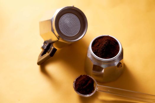 Open geyser coffee maker with fresh coffee on a yellow background. High quality photo