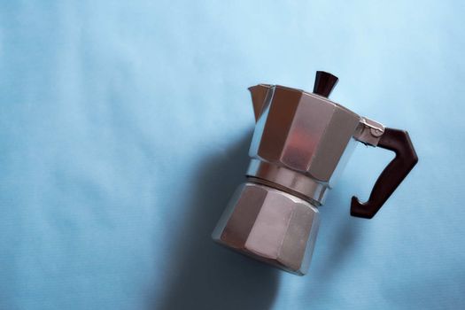 The geyser coffee maker lies on a blue background. . High quality photo