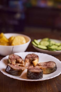 pieces of sardine in a plate on a brown table. High quality photo