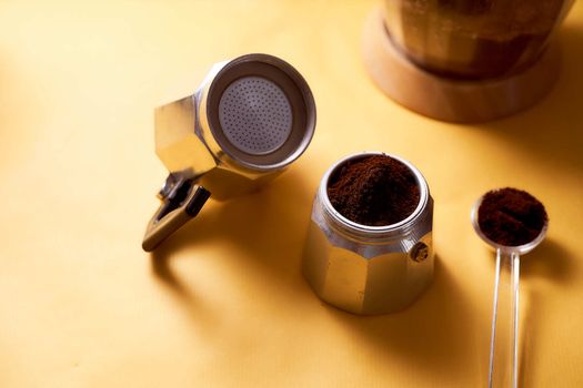 Open geyser coffee maker with fresh coffee on a yellow background. High quality photo