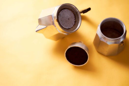 Open geyser coffee maker with fresh coffee on a yellow background. High quality photo