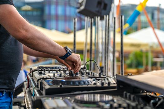 Dj mixes music at an outdoor party.