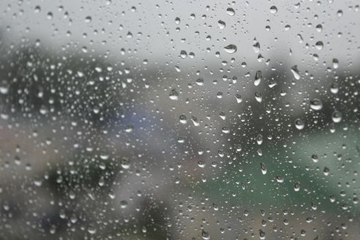 Drops of rain on the window, rainy day. Shallow DOF