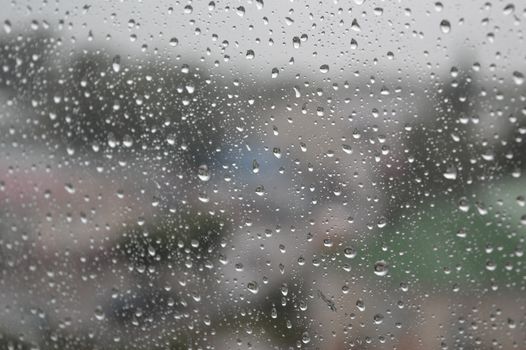 Drops of rain on the window, rainy day. Shallow DOF