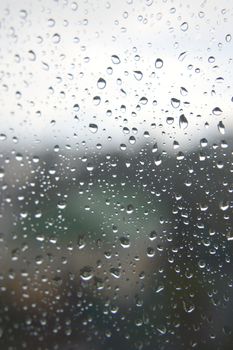 Drops of rain on the window, rainy day. Shallow DOF