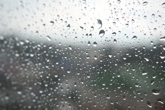 Drops of rain on the window, rainy day. Shallow DOF