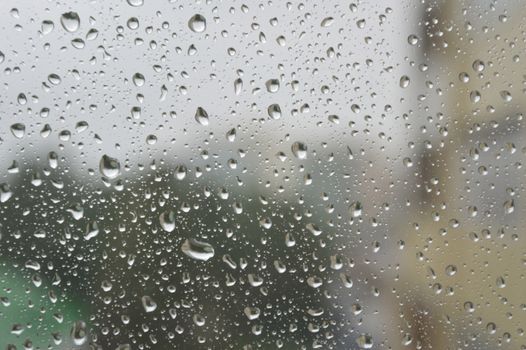 Drops of rain on the window, rainy day. Shallow DOF