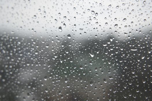 Drops of rain on the window, rainy day. Shallow DOF