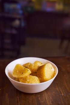 Boiled potatoes with mslom seasonings in a plate on a brown background. High quality photo