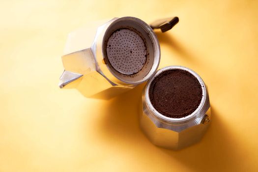 Open geyser coffee maker with fresh coffee on a yellow background. High quality photo