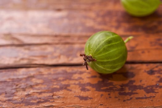 The fruit of the green gooseberry on wooden table. Close-up. With copy space. High quality photo