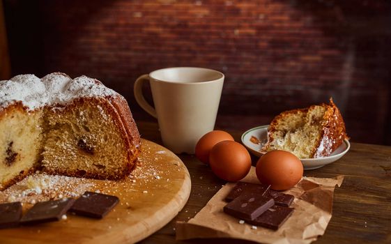 Chocolate cakes stacked on a wooden table. next to it are eggs and pieces of chocolate. blurred background. High quality photo