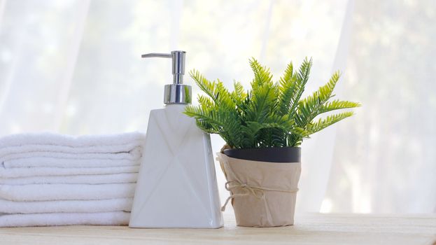 Bottle of liquid soap and white towels Put on the table in the bathroom