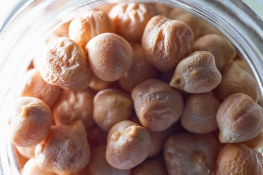 Superfood chickpeas lie in a glass jar. High quality photo