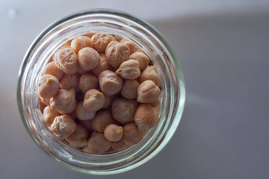 Superfood chickpeas lie in a glass jar. High quality photo