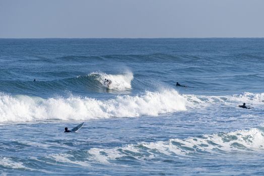 Sporty surfing friends with big longboard surf surfboard board. Modern active sport lifestyle and summer vacation.