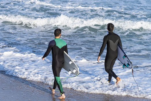 Two sporty surfing friends with big longboard surf surfboard board. Modern active sports lifestyle and summer vacation.