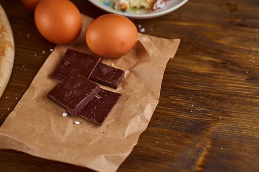 eggs and pieces of chocolate lie on a brown board. High quality photo