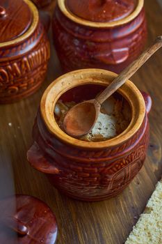 Homemade food. Potatoes and fish in clay pots on a wooden table . High quality photo
