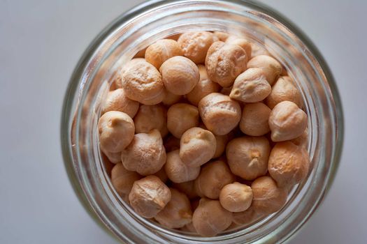 Superfood chickpeas lie in a glass jar. High quality photo