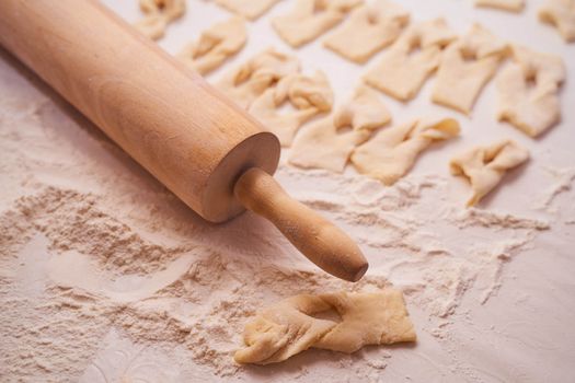 Homemade dough with a rolling pin on a light background of flour. High quality photo