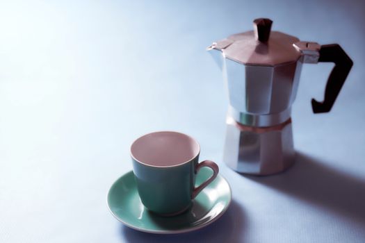 The geyser coffee maker stands on a blue background. . High quality photo