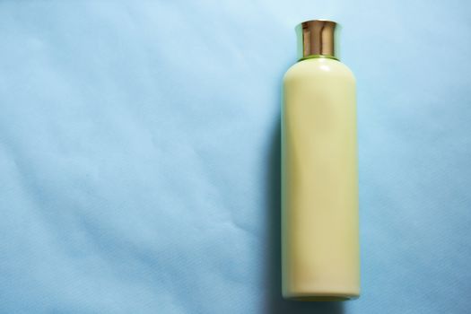 Yellow vial for cosmetics on a blue background. High quality photo