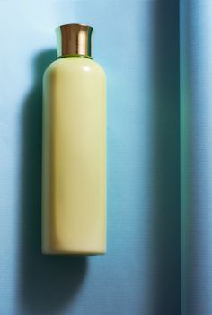 Yellow vial for cosmetics on a blue background. High quality photo