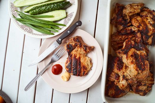 Ready pork steak in a white plate with green onions on a white plate. With copy space. High quality photo