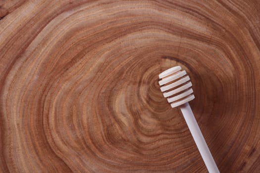 wooden honey dipper lies on a slice of a tree. wooden table. With copy space. High quality photo