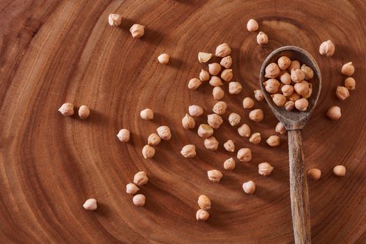 Superfood chickpeas lie in wooden background with spoon. Close-up. Top view. High quality photo