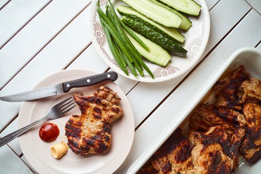 Ready pork steak in a white plate with green onions on a white plate. With copy space. High quality photo