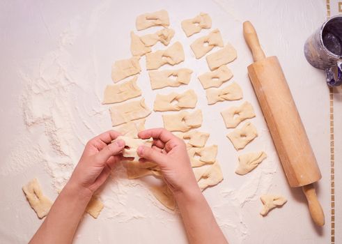 Women's hands form a variety of shapes from the dough. High quality photo