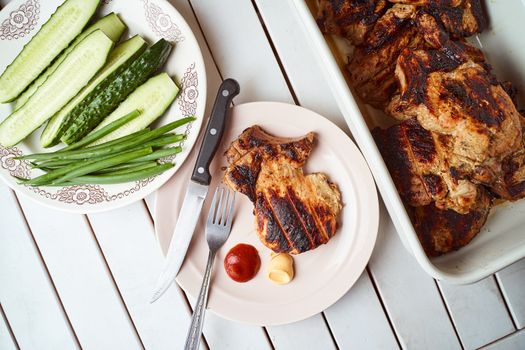 Ready pork steak in a white plate with green onions on a white plate. With copy space. High quality photo