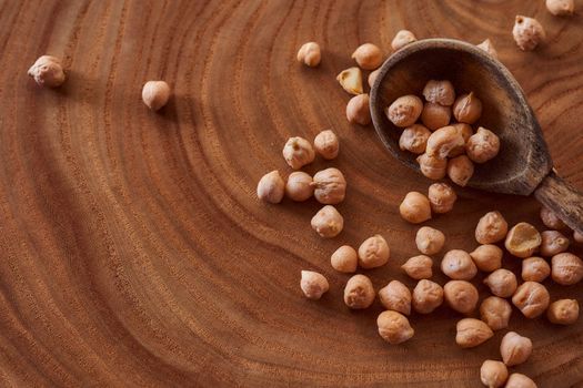 Superfood chickpeas lie in wooden background with spoon. Close-up. Top view. High quality photo