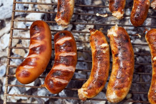 Homemade grilled meat sausages in a white plate on a green background. High quality photo