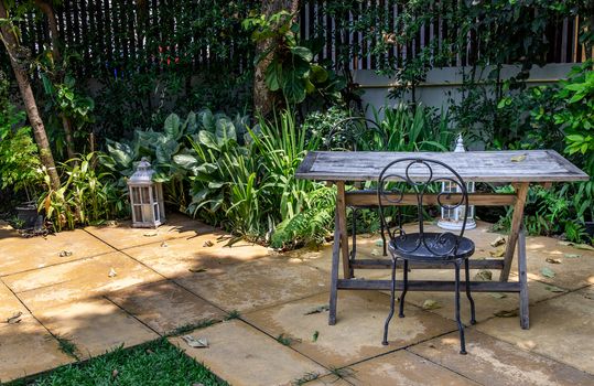 Old wooden table and black steel chair for outdoor gardens. Selective focus.