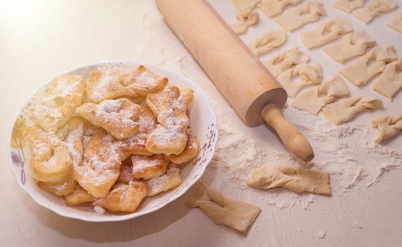 Homemade pastry, sprinkled with powdered sugar on a light table. High quality photo