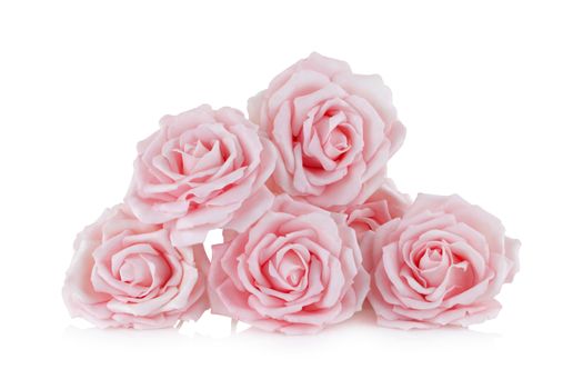 Pink paper roses on white background with reflection