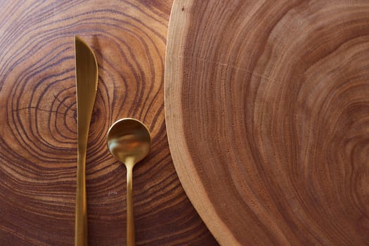 The golden fork lies on a slice of a tree. wooden table. High quality photo