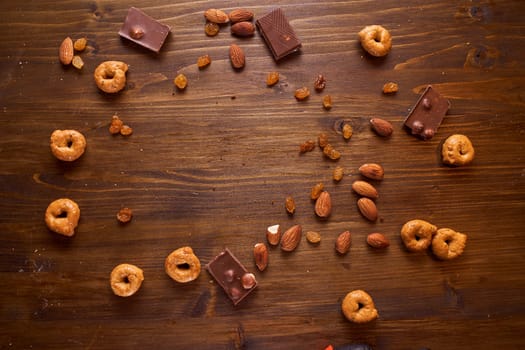 composition of scattered nuts, chocolate and tartallin on a brown background with text. High quality photo