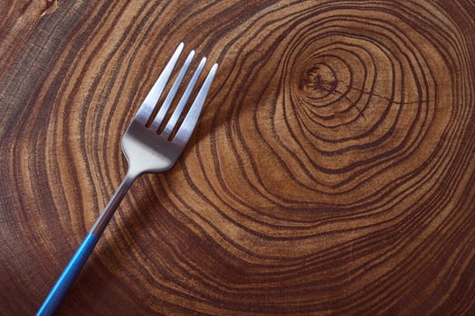 The silver fork lies on a slice of a tree. wooden table. High quality photo