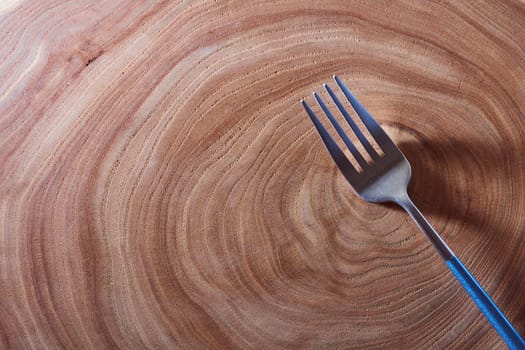 The silver fork lies on a slice of a tree. wooden table. High quality photo