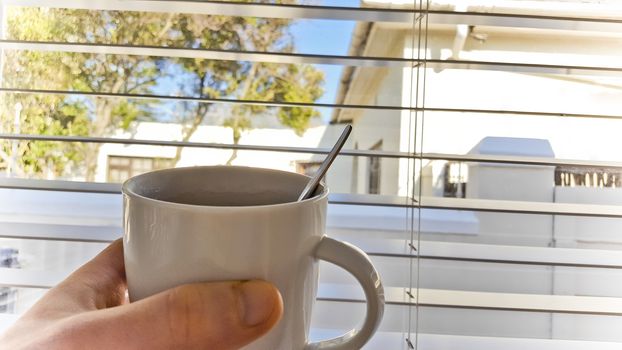 Looking outside behind bars with a cup of coffee Cape Town, South Africa.