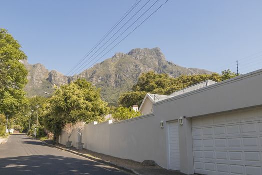 Street in the town of Claremont, Cape Town, South Africa. Sunny weather and panorama of Table Mountains.