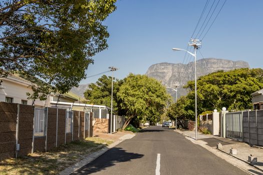 Street in the town of Claremont, Cape Town, South Africa. Sunny weather and panorama of Table Mountains.