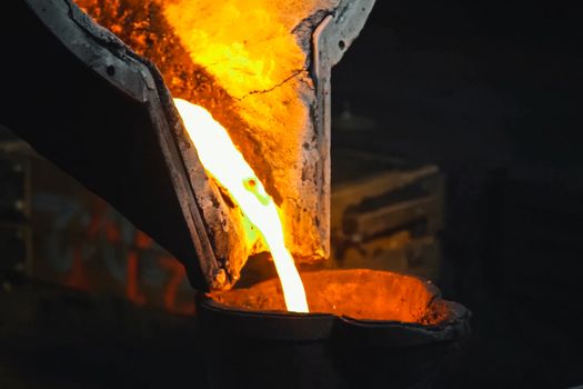 Molten metal flows out of a furnace in a smelter.