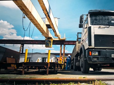 Truck before loading in the loading shop. The metal base is a construction site.